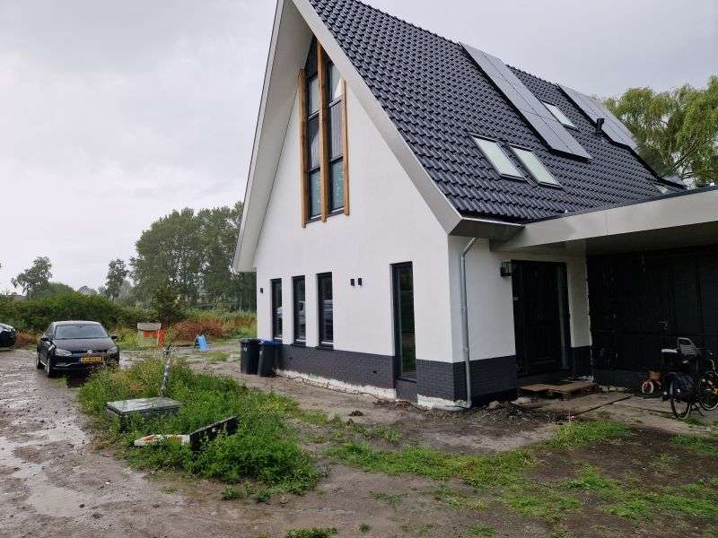 Villa met geïsoleerde gevels met stucwerk en steenstrips afwerking in West-Friesland