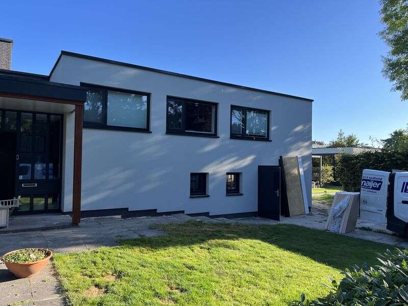 Woning voorzien gevelisolatie, stucwerk en steenstrips in Hoogwoud